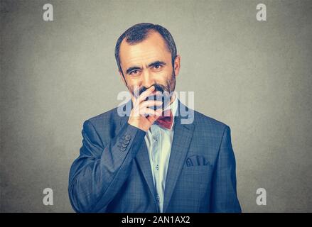 Homme d'affaires en pensées regardant vous pensif appareil photo. Modèle mixte barbu isolé sur fond gris avec espace de copie. Image horizontale. Banque D'Images