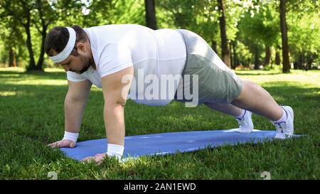 Gros homme faisant planche, entraînement à l'extérieur, désir d'être mince, motivation saule Banque D'Images