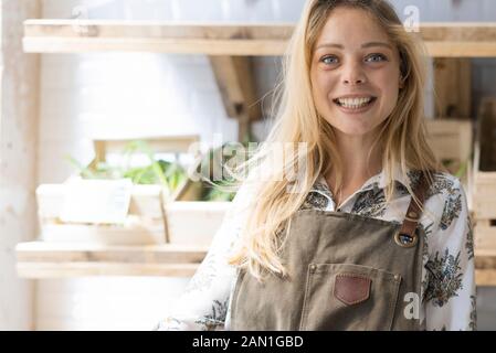 Jeune femme souriante tenant un panier en osier à l'épicerie Banque D'Images