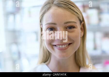 Portrait de la jeune femme souriante debout en pharmacie Banque D'Images