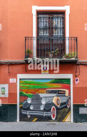 Une peinture colorée d'une voiture d'époque à la porte d'un garage à Séville Banque D'Images