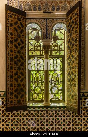 Un châssis de fenêtres décorées en voûte très ornées très fenêtre sur le jardin du palais de l'Alcazar. Banque D'Images