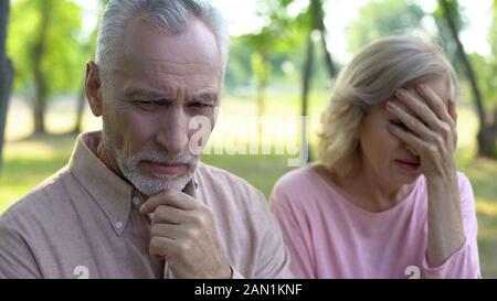 Man se sentir triste et coupable, épouse de pleurer assis à part, couple divorce Banque D'Images