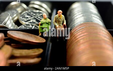 Miniatures, couple retraité assis sur l'argent,cash,pièces,concept Banque D'Images