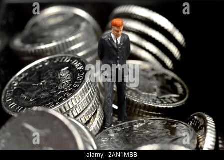 homme d'affaires miniature de figurine, debout en pièces de monnaie, gros plan, macro Banque D'Images