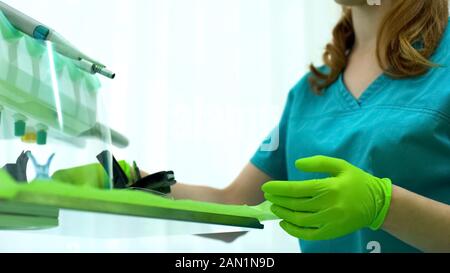 Femme dentiste préparer l'équipement pour l'opération, en portant des gants protecteurs Banque D'Images