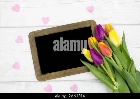 Belle Vue de dessus/coloré tulipes colorées avec un écran blanc, tableau sur un tableau blanc rustique - Prix pour le texte Banque D'Images