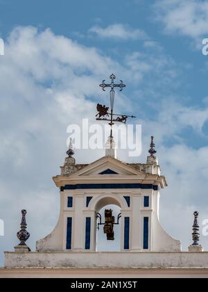 Une croix en fer forgé et ornementé girouette haut beffroi de l'Église Santiago en la Plaza de Jésus de la Redencion à Séville Banque D'Images