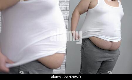 Les hommes obèses mettant sur chemise blanche en face du miroir, le désir de perdre du poids Banque D'Images
