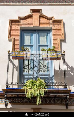 Un cadre en briques élaborées orne les fenêtres françaises sur un balcon dans une maison de la Calle Pelay Correa à Triana, Séville Banque D'Images