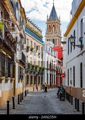 Le 14ème clocher gothique-mudéjar de l'Iglesia de Santa Ana se dresse au-dessus des bâtiments colorés bordant la Calle Pelay Correa à Triana. Banque D'Images