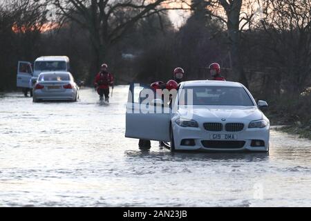 Le personnel de secours et de pompiers de Wiltshire qui tente de déplacer des voitures bloquées sur la route inondée de B4069 à Christian Malford dans le Wiltshire après que la rivière Avon ait fait éclater ses rives. Banque D'Images