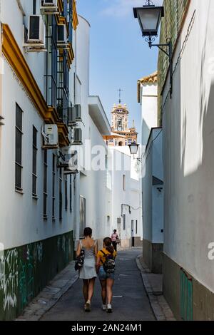 Le beffroi de l'école du Convento de Santa Isabel s'élève au-dessus des maisons blanchies à la chaux bordant l'étroite et sinueuse Calle Santa Paula. Banque D'Images