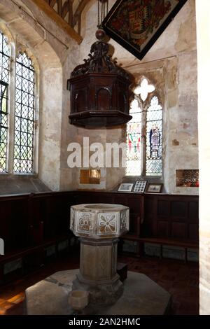 Police baptismale en pierre sculptée et couverture en bois à l'intérieur de l'église St Mary's, Chiddingstone, Kent, Angleterre Banque D'Images