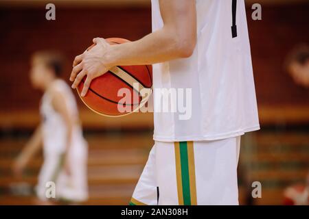 Joueur de basket-ball junior sur le jeu. Arrière-plan de la ligue de basket-ball pour les jeunes Banque D'Images