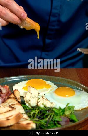 Homme mange des oeufs dans un restaurant Banque D'Images