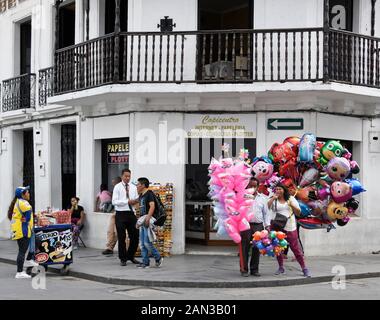 Vendeurs vendant de la nourriture, des bonbons en coton, des ballons et des lunettes de soleil sur un coin de rue à l'extérieur d'un centre de copie, 'White City' de Popayan, Colombie Banque D'Images