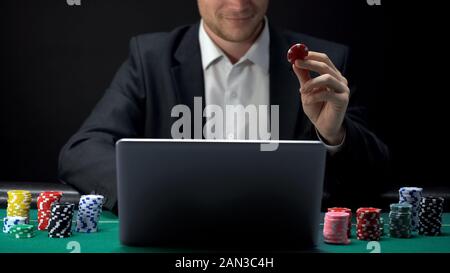 A business man placing bet avec assurance en ligne sur ordinateur portable, site web casino Banque D'Images