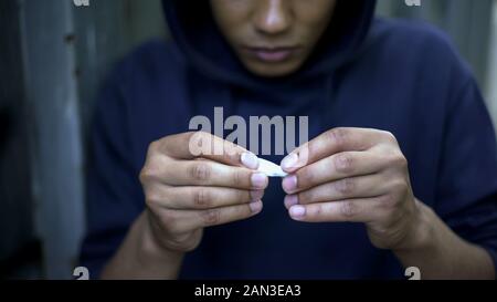 Adolescent toxicomane rendant la cigarette avec de la marijuana, des problèmes de santé risque, de l'oncologie Banque D'Images