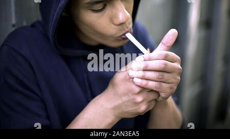 Afro-american man exhalant la fumée de cigarette, abattage cool, atteinte à la santé Banque D'Images