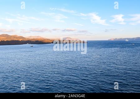 Les petites îles et les navires de croisière à l'intérieur de la caldeira de Santorin, Grèce. Banque D'Images