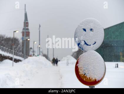 Panneau de circulation enneigé avec un visage souriant dessiné dans la neige dans le centre de Helsinki, Finlande Banque D'Images