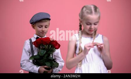 Garçon Gentleman prêt à donner bouquet de roses rouges de petite dame, Valentines Day Banque D'Images