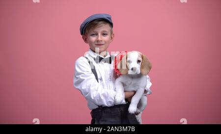 Kid holding mâle chiot avec red bow, cute animal, animal adoption concept, don Banque D'Images