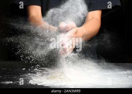 Les mains du cuisinier n'est frappant avec la farine Banque D'Images