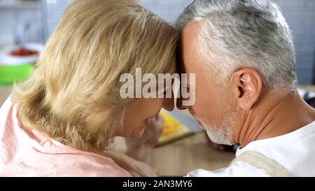 Couple de retraités nuzzling positif, homme et femme, à l'affection, l'amour, le soutien de la vieillesse Banque D'Images