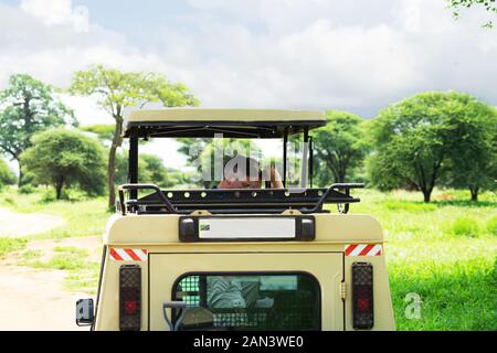 La Tanzanie, le parc national du Serengeti - janvier 03, 2020 : les touristes du véhicule utilitaire jeep, photographié les animaux sauvages d'espèces sauvages sur safari en jeep. Banque D'Images