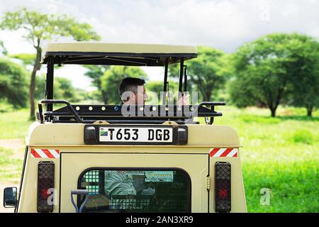 La Tanzanie, le parc national du Serengeti - janvier 03, 2020 : les touristes du véhicule utilitaire jeep, photographié les animaux sauvages d'espèces sauvages sur safari en jeep. Banque D'Images