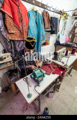 5 mars 2019 : Un vieil homme sur mesure dans un en utilisant une machine à coudre. Yazd, Iran Banque D'Images