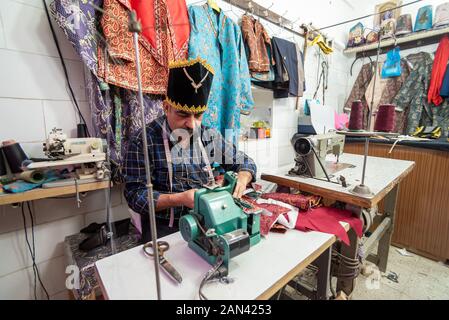 5 mars 2019 : Un vieil homme sur mesure dans un en utilisant une machine à coudre. Yazd, Iran Banque D'Images