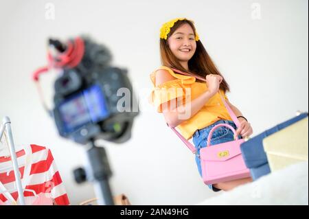 Beauty Vlogger asiatique Vente en ligne sac femme blogger avec appareil photo numérique reflex numériques professionnels film vidéo live. Coaching femme et de l'examen d'effectuer de Banque D'Images