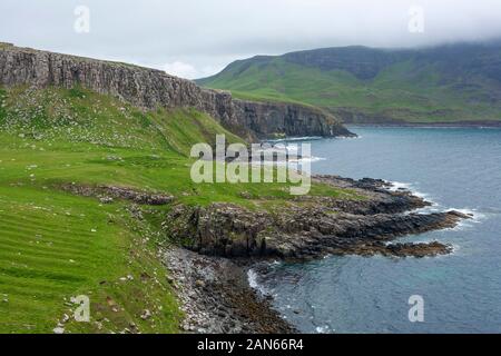 Neist Point Lighthouse, champs, falaises, et des moutons sur l'île de Skye en Écosse. Banque D'Images