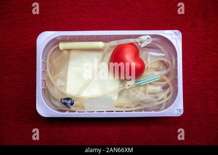Un cœur rouge boule gonflable avec poche de sang dans le panier. Les soins de santé et de bienfaisance. Concept de don du sang Banque D'Images