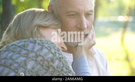 Prendre soin femme dans son 50s toucher tendrement face mari, relation et l'amour Banque D'Images