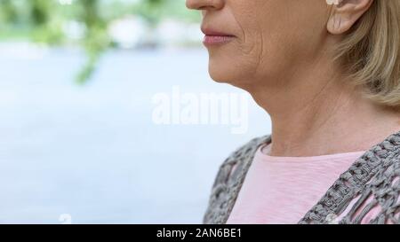 Vieille Femme ridée close up, une maladie de la glande thyroïde, examen médical, santé Banque D'Images