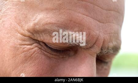 Retraite froissé homme yeux close-up, rappel des hommes, de la sécurité sociale Banque D'Images