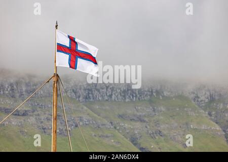 Drapeau des îles Féroé et le symbole en agitant le paysage du fjord. Danemark Banque D'Images