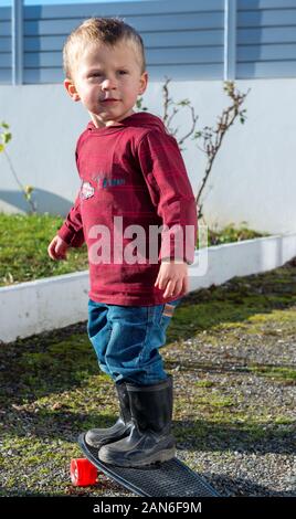 Jeune garçon avec paire de bottes Banque D'Images