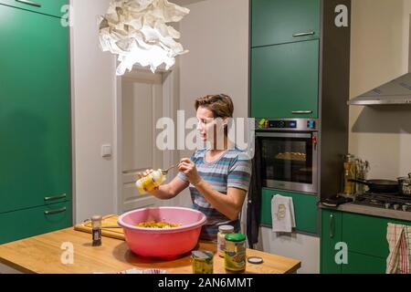 Femme prepareing beaucoup de repas en plastique dans la cuisine Banque D'Images