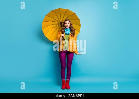 Full Size photo de jolie dame voyageur tenir parapluie lumineux profitez de la saison ensoleillée chaude journée de marche street wear Pantalon violet écharpe manteau jaune chaussures rouge Banque D'Images