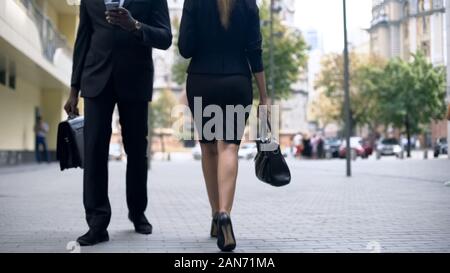 Business people walking on street, contrôle du courrier sur smartphone, style de vie occupé Banque D'Images