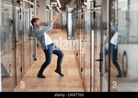 Drôle de danse masculine millénaire dans le couloir des succès à célébrer Banque D'Images