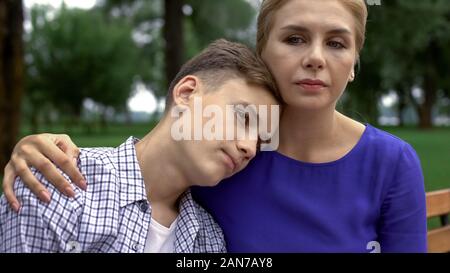 Jeune fils dans le désespoir en mettant la tête sur l'épaule de mères et de l'amour sentiment de calme Banque D'Images