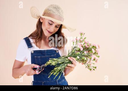 Jeune femme avec des sécateurs à fleurs de coupe Banque D'Images