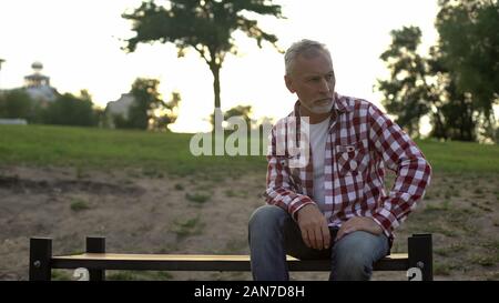 Mélancolique, hommes âgés assis sur un banc de parc et réfléchir aux problèmes Banque D'Images