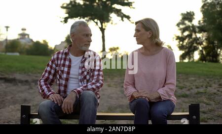 Offensé senior couple assis sur un banc et regarder les uns les autres, les relations Banque D'Images